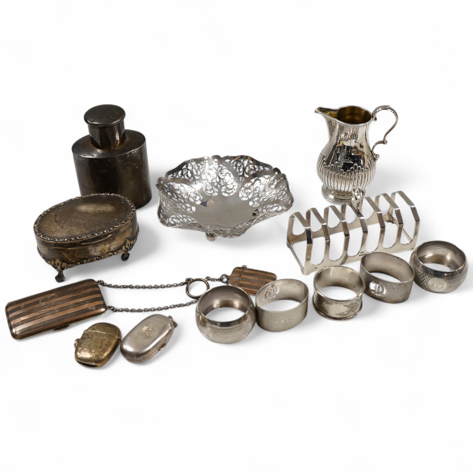 Sundry small silver including an Edwardian oval tea caddy, Hasseler Brothers, London, 1901, 10.4cm, a pierced bonbon dish, a late Victorian cream jug, five napkin rings including two pairs, a seven bar toast rack, a dama